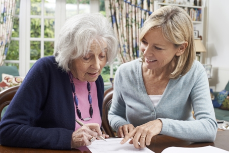 Younger Woman Helping Senior Woman to Complete Form | Dorcey Law Firm